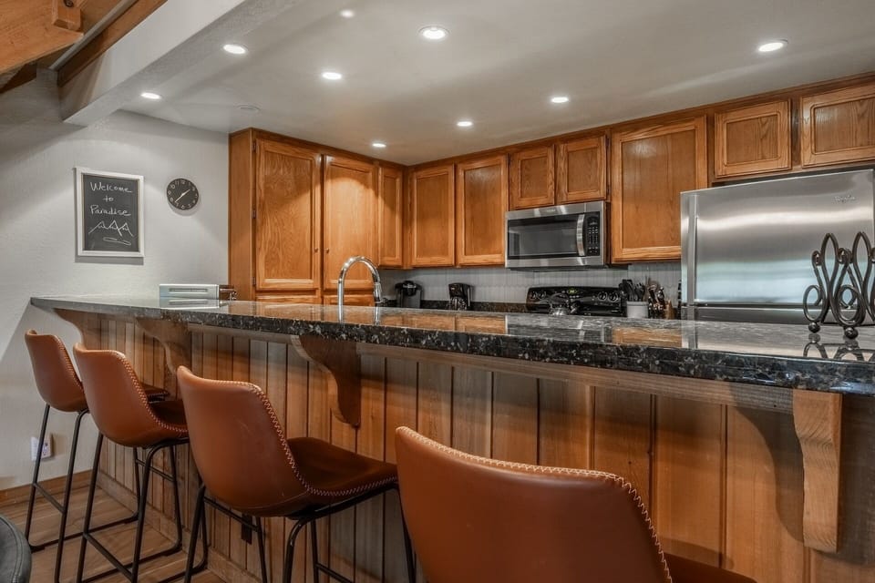 Step into your spacious kitchen, where warm wood cabinetry and gleaming granite countertops create the perfect space to cook, gather, and share meals with loved ones.