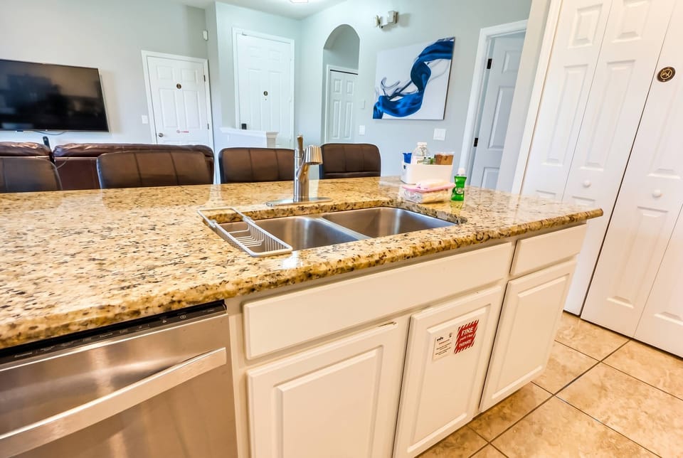 Enjoy culinary creativity in the stylish kitchen with granite countertops and bright white cabinetry. The open layout flows into the living area, perfect for creating an inviting atmosphere for memorable gatherings.