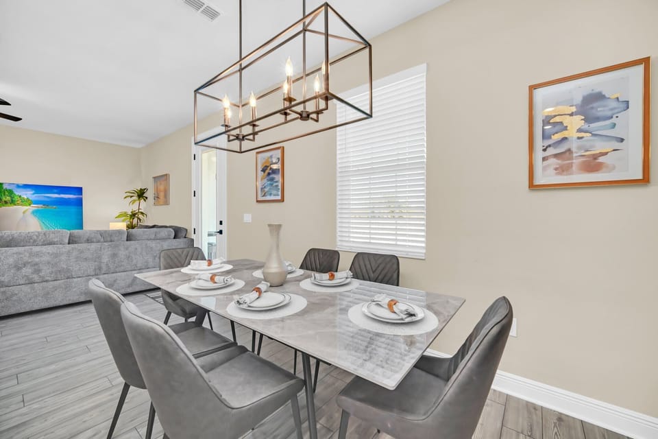 Modern dining area with a marble table and gray upholstered chairs for comfortable meals.