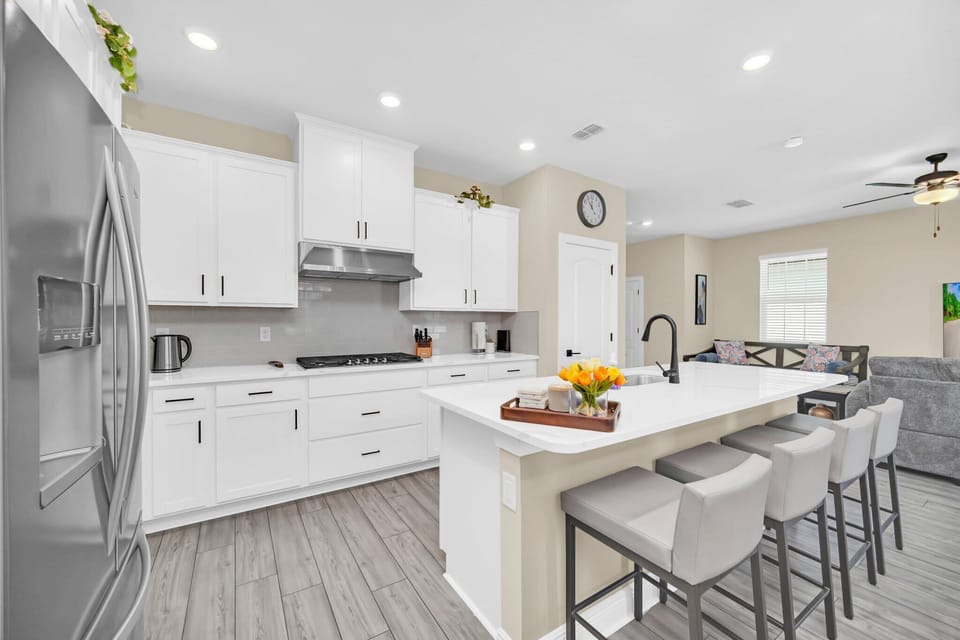 Modern kitchen with white cabinetry and a large island with seating