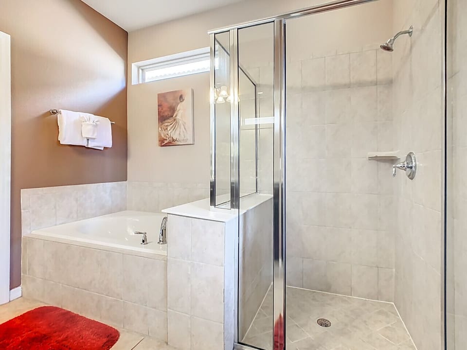 Bright bathroom with a soaking tub and glass-enclosed shower.
