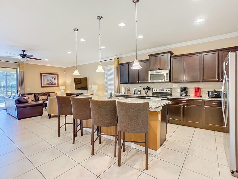 Gourmet kitchen featuring a large island with bar seating, opening into the cozy living space.