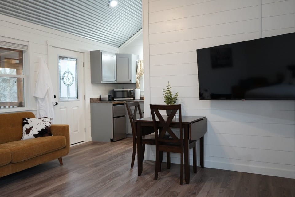 Open-concept living with a modern kitchenette, dining area, and smart TV.