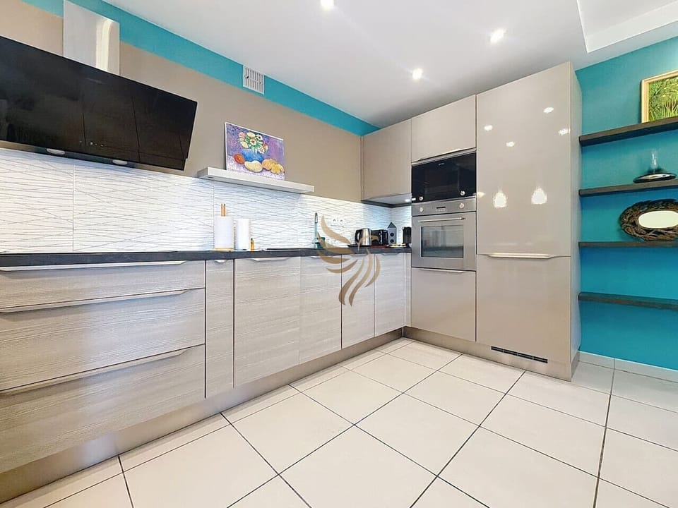 Cuisine moderne avec électroménager complet et rangements.
