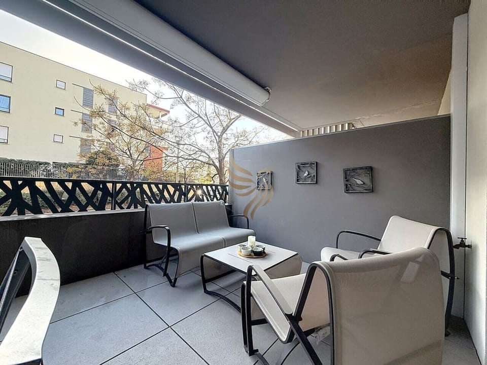 Terrasse aménagée avec salon extérieur (fauteuils + canapé + table basse) et coin repas 4 places.