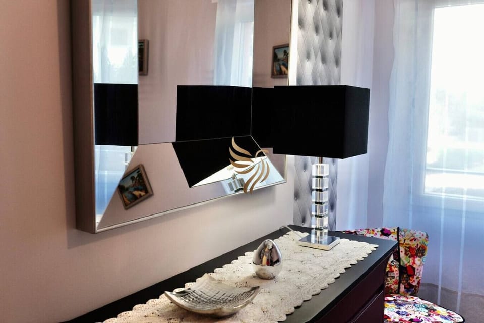 Commode, miroir XXL et lampe design, ambiance suite hôtelière raffinée.
