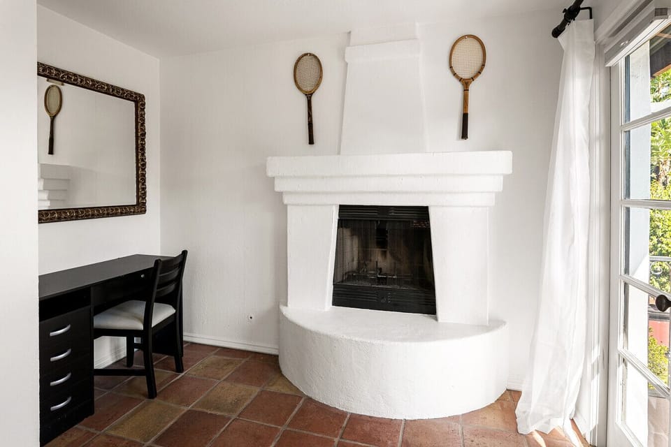 Enjoy the cozy ambiance of a decorative fireplace, thoughtfully styled with classic tennis rackets that reflect the home’s tennis-inspired charm.