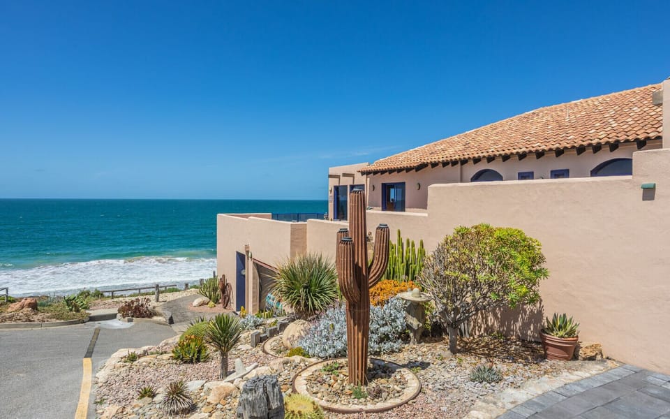 Arrive through a desert-style garden that mirrors the home’s warm Mediterranean character.
