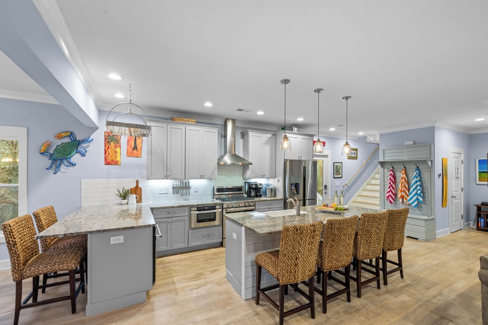 Kitchen view showing the full layout and breakfast bar with barstools.