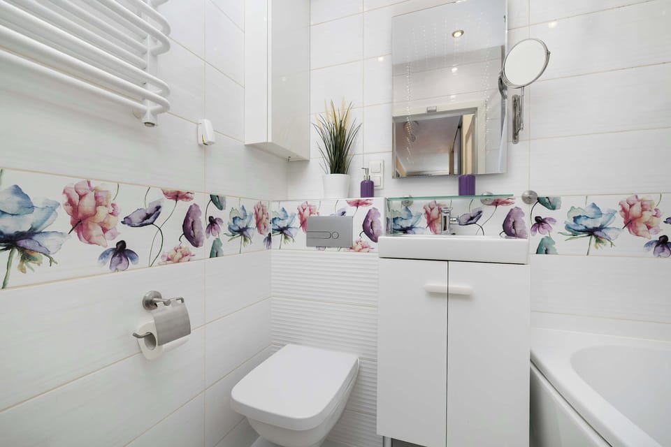 Another bathroom view showing a toilet, sink, and wall décor. The layout is practical and uncluttered. Light colors dominate the room.