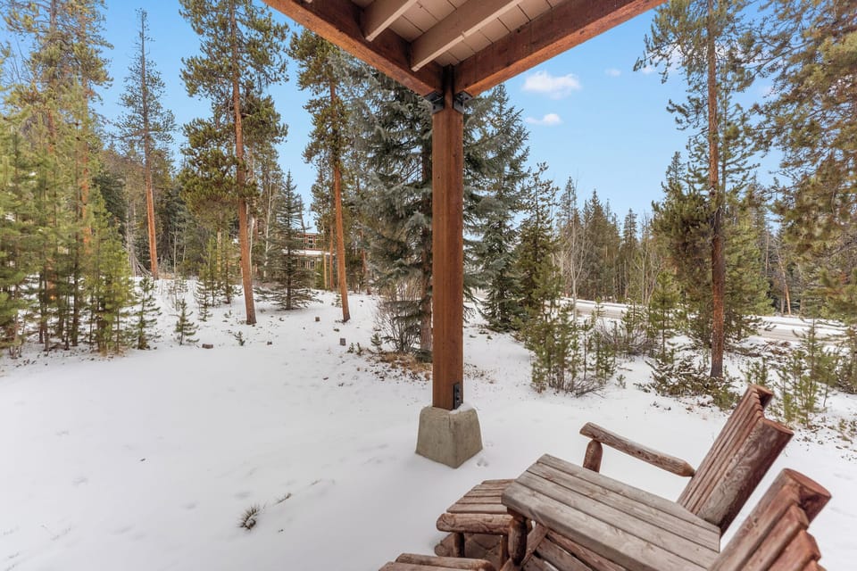 Relax on your private covered patio with rustic seating, surrounded by pristine snow and towering pine trees.