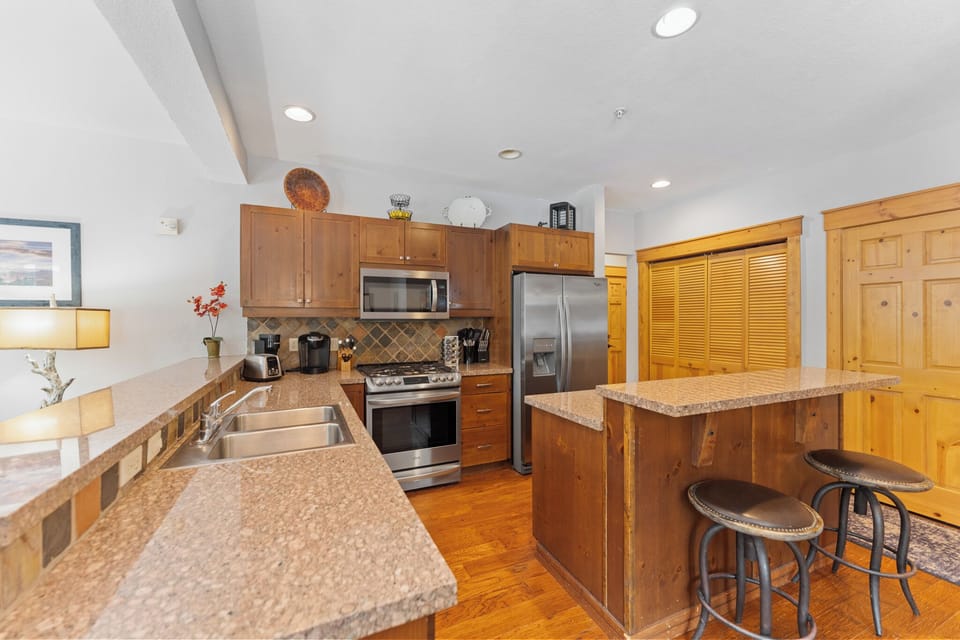 Your fully equipped kitchen features granite counters, stainless appliances, and a breakfast bar where you can enjoy morning coffee.