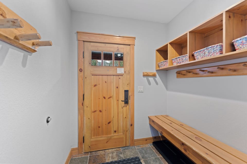 Step into your cozy mudroom with warm wood benches and shelving to organize your mountain gear and keep your space tidy.