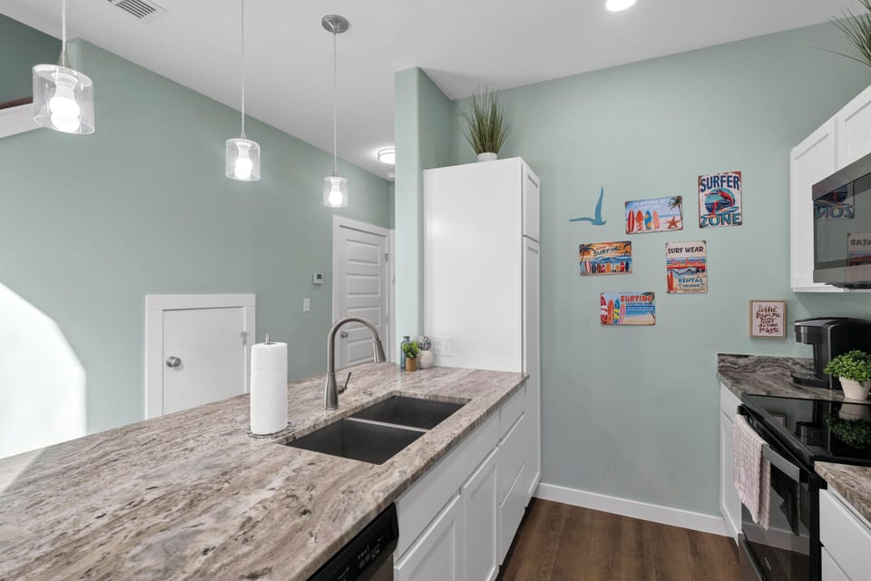You'll love preparing meals in this bright, modern kitchen with granite countertops, stainless steel appliances, and cheerful coastal-themed décor.