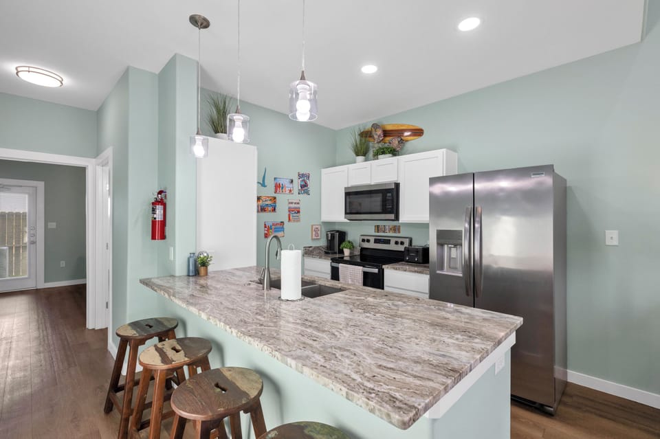Gather around this stunning kitchen island with marble countertops where you can cook, chat, and create memories together.
