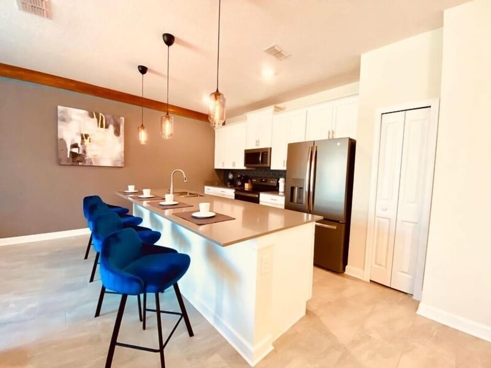 Your modern kitchen awaits with sleek white cabinets, stainless appliances, and a stylish breakfast bar where morning coffee feels extra special.