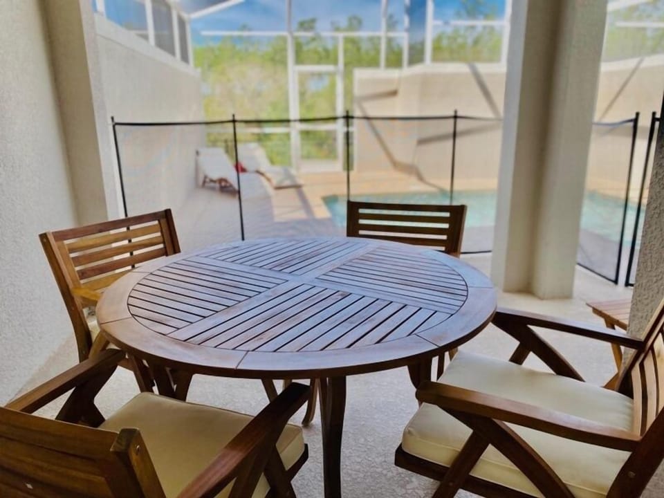 Enjoy your morning coffee at your private dining table with stunning pool views through floor-to-ceiling windows.