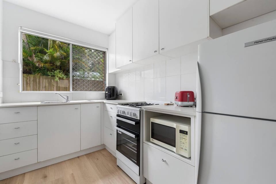 Bright and functional, the kitchen supports easy home cooking with a full-size fridge, gas cooktop, oven, microwave, and generous storage.