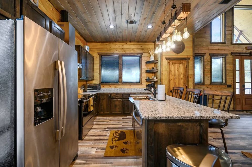 Your rustic retreat features a stunning kitchen with granite countertops, stainless steel appliances, and warm wood details throughout.