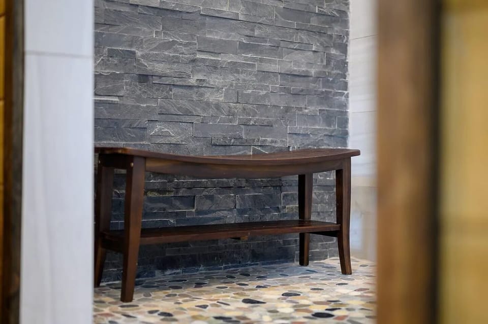 Your wooden table sits gracefully against stunning stone brick walls, creating a warm workspace perfect for morning coffee or evening planning.