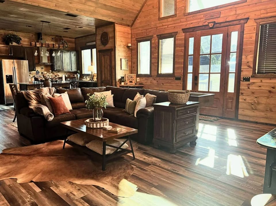 Sink into your private rustic retreat where rich wood walls embrace plush seating and natural light streams through expansive windows.