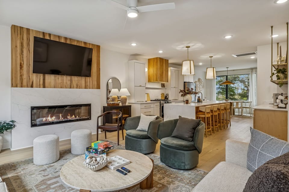 Living Room: Experience sophisticated living. From the sleek fireplace feature to the inviting sofa and fully-equipped kitchen, every detail in this space is curated for your ultimate comfort and enjoyment.