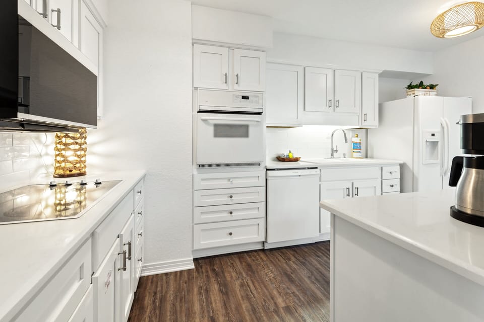 Your bright, fully-equipped kitchen invites culinary adventures with gleaming countertops, modern appliances, and ample storage for all your cooking needs.