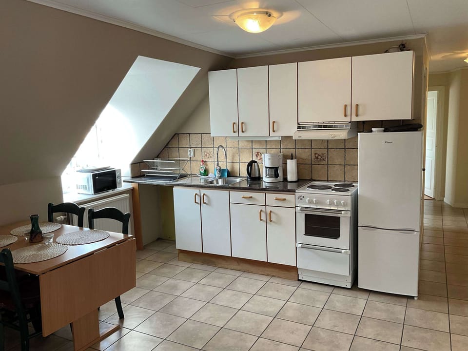 A fully equipped kitchen with all essentials you will need for a home cooked meal. There is a stove, oven, fridge, freezer, coffee maker, kettle and silverware. 