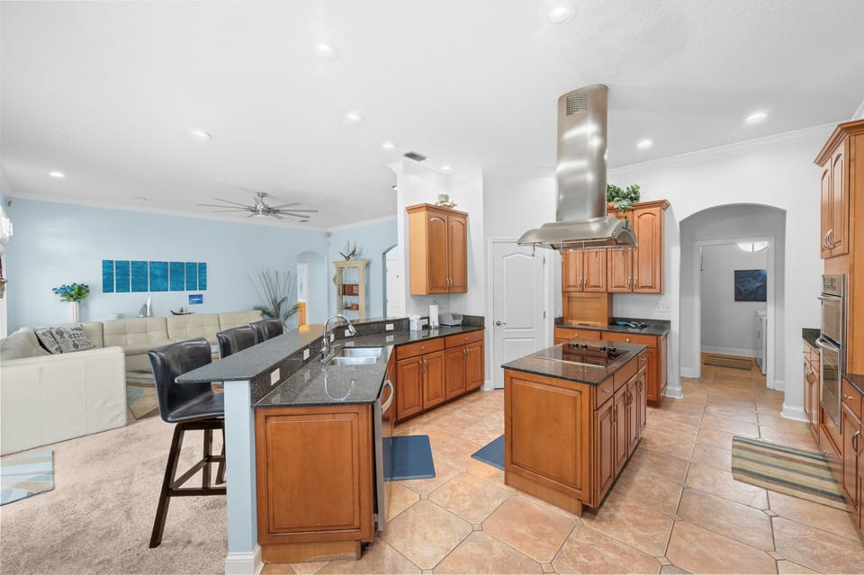 Open-concept living area with full kitchen, island seating, and cozy lounge.