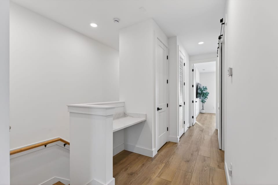 The bright and airy upper-level hallway showcases clean lines and stylish accents, inviting guests to explore the comfort of their vacation rental.