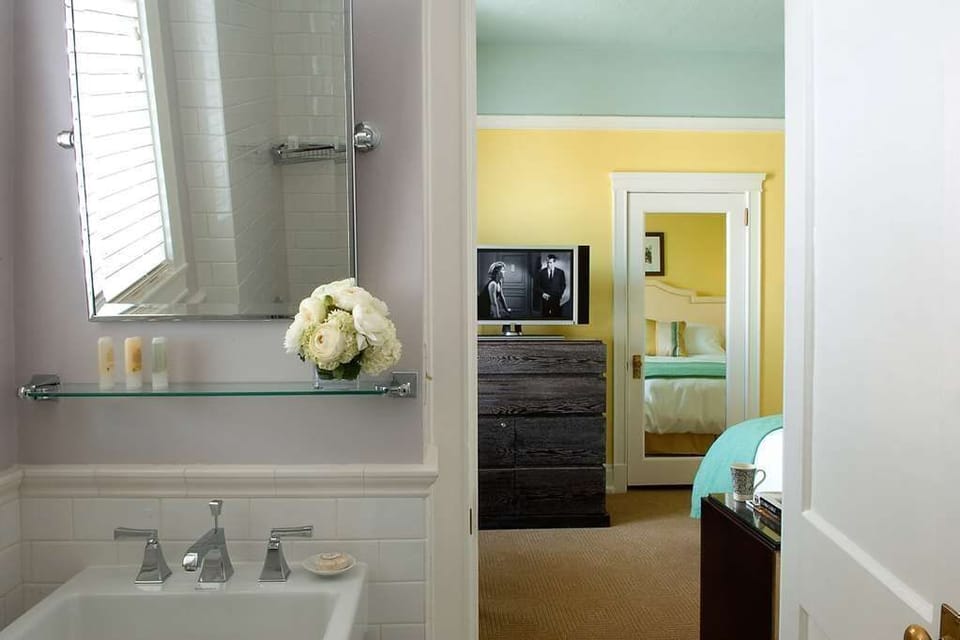 Stylish comfort awaits in this beautifully connected bathroom and bedroom, blending modern finishes with playful color.