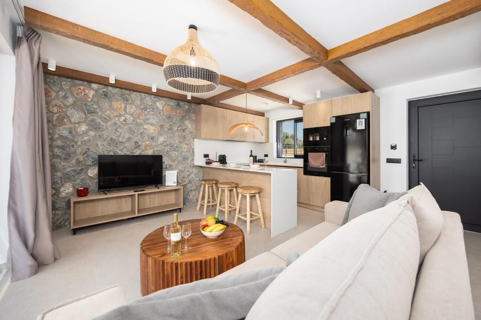 Open-plan living room with sofa, breakfast bar, kitchen, A/C, WiFi internet, and satellite TV