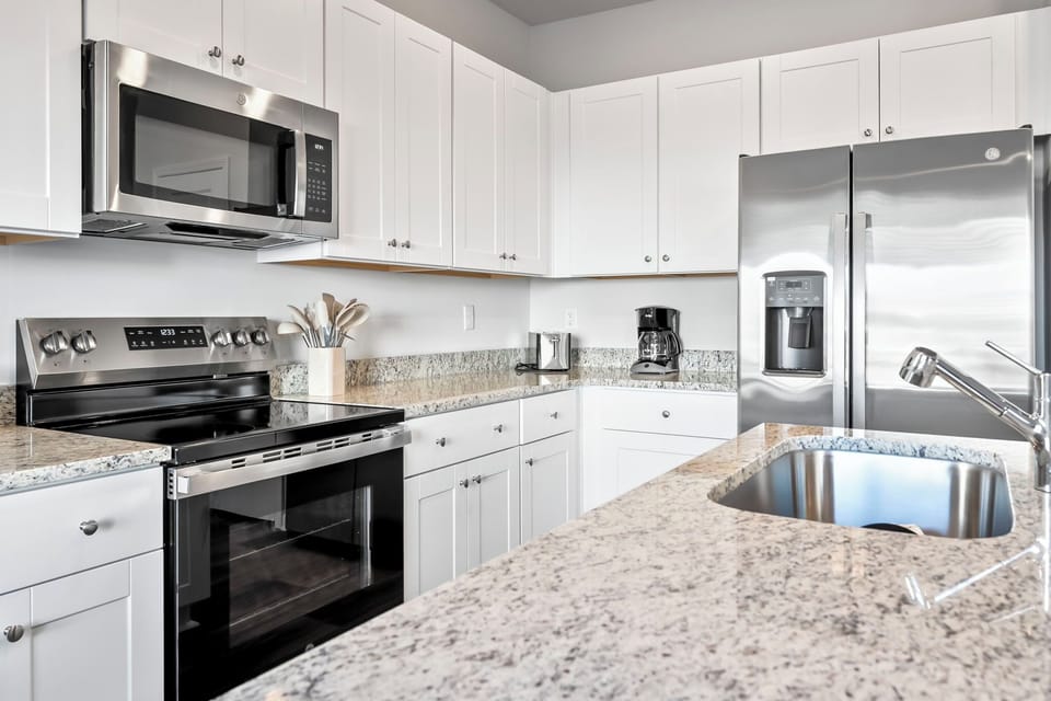 New kitchen with stainless steel appliances and granite countertops