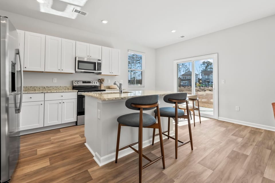 Kitchen with granite countertops and dining table seating 6