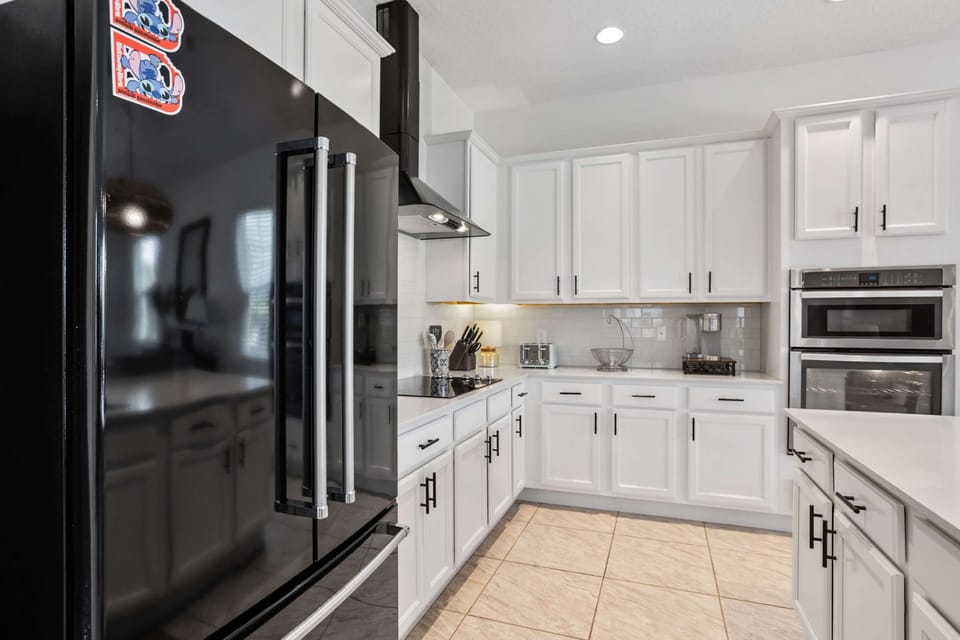 Large refrigerator and additional kitchen workspace, ideal for storing groceries for family vacations or group trips.