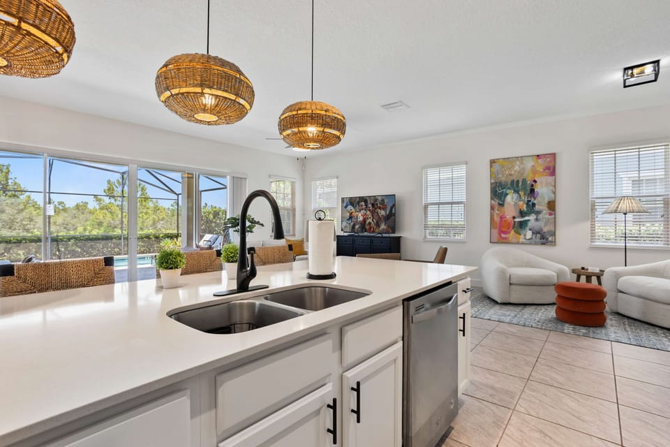 Spacious kitchen island with quartz countertops, modern pendant lighting, and an open flow into the living area.