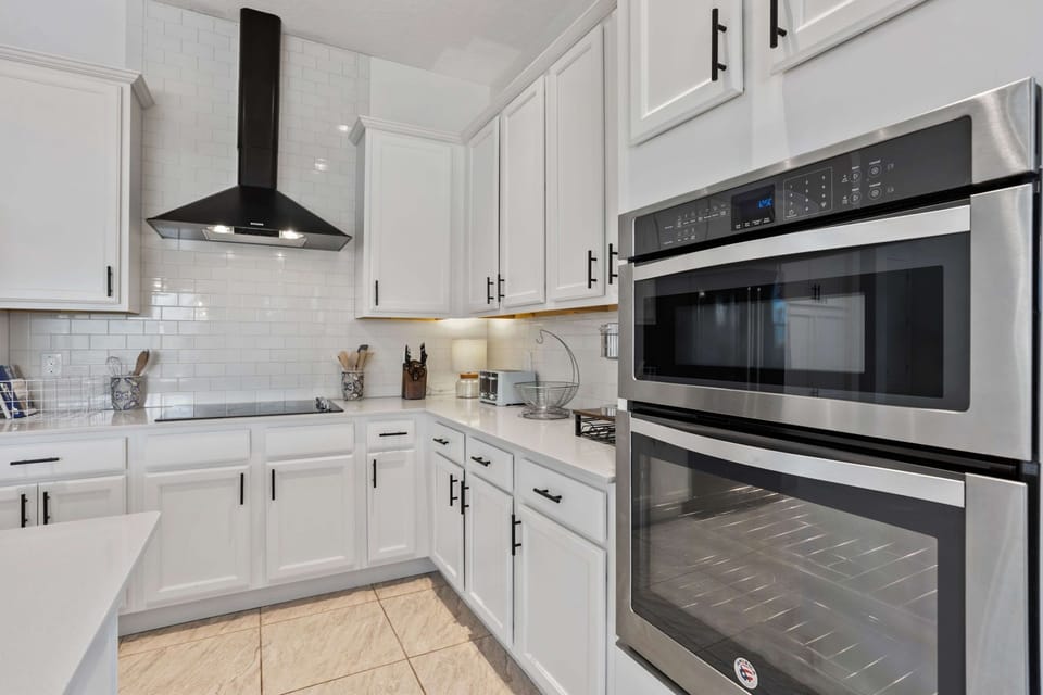 Fully equipped gourmet kitchen with stainless steel appliances, double ovens, and ample cabinet space for extended stays