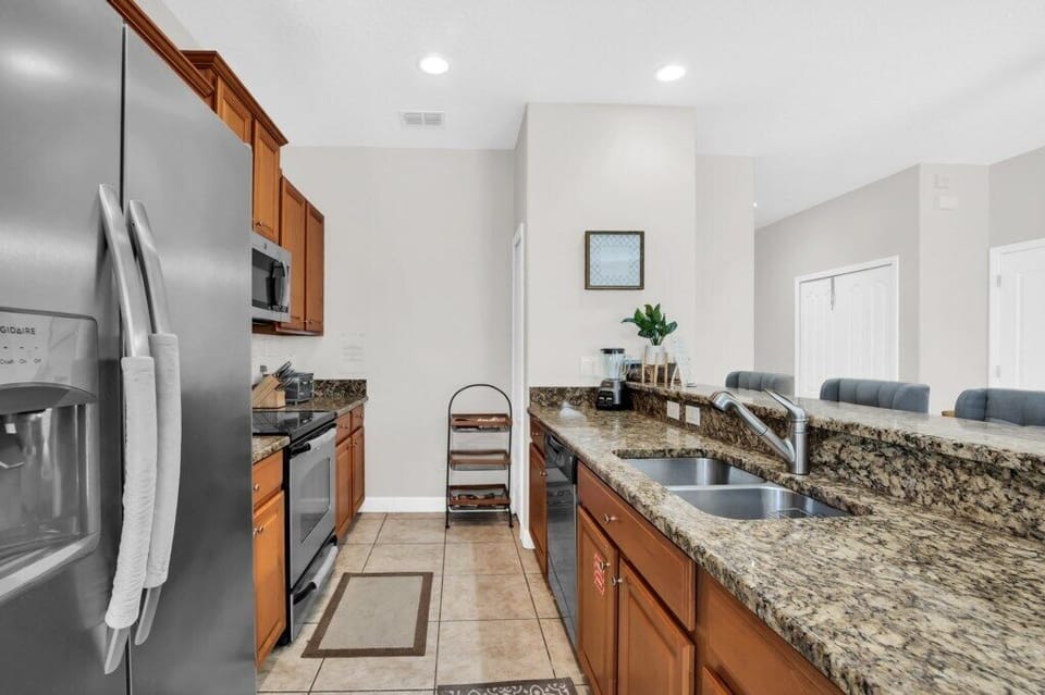 A stainless steel refrigerator and spacious kitchen layout with generous countertop space.