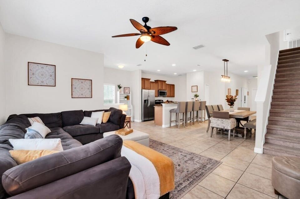 An open living-and-dining area featuring a large sectional sofa and warm, modern décor