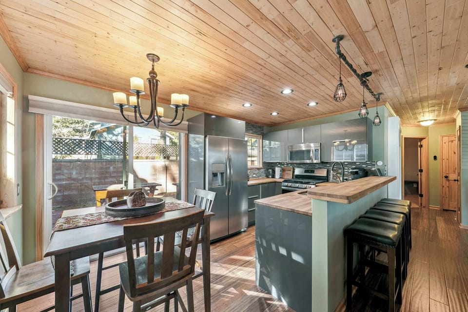 Warm, stylish kitchen with wood ceilings, modern appliances, and plenty of space—perfect for cooking together and gathering over meals.
