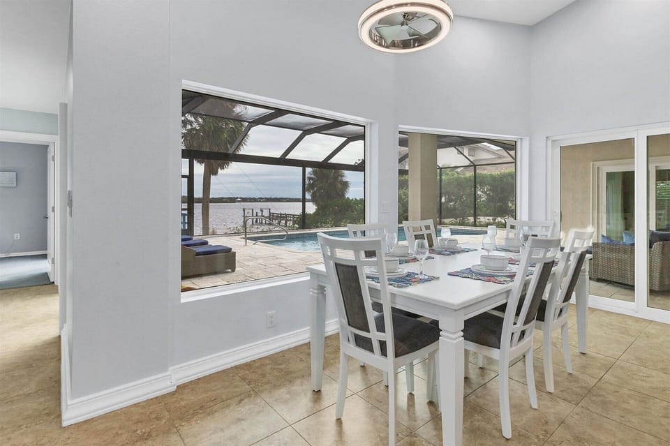 Dining area with water view. Dining table seats six, with additional seating for four at the kitchen island