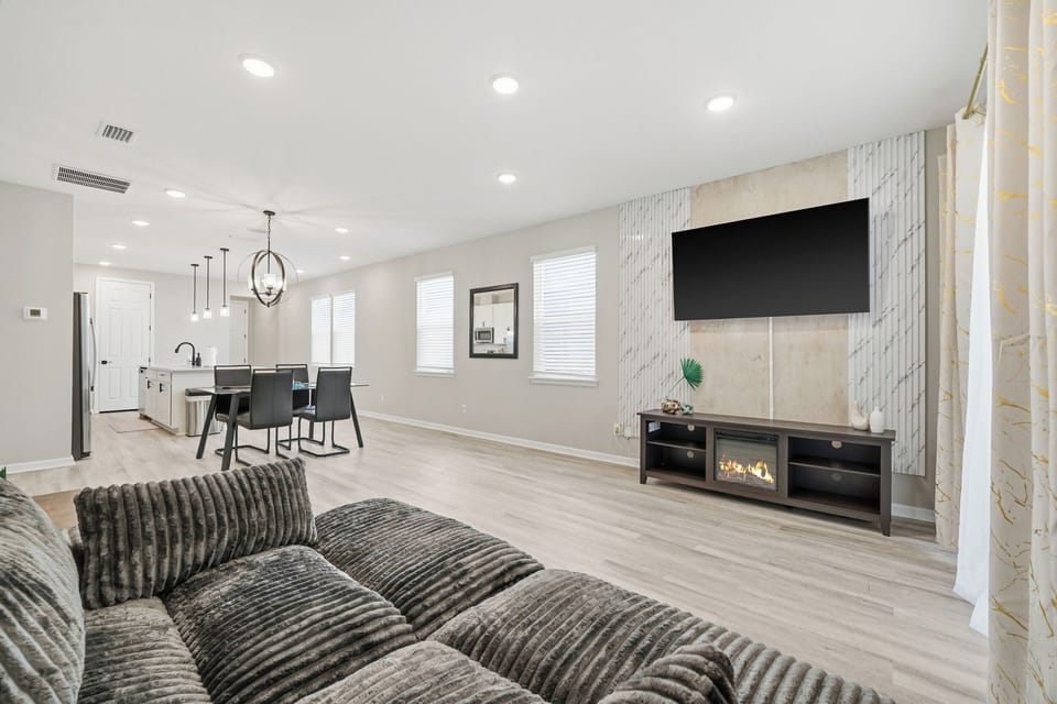 Electric fireplace sits under the huge living room TV
