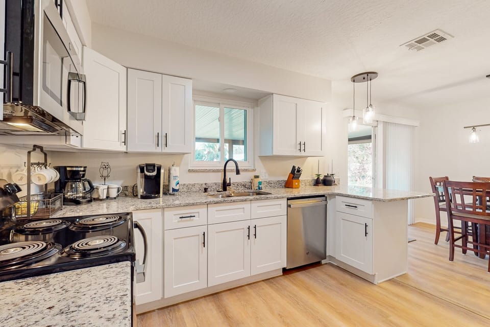 The kitchen features granite counterops, white shaker cabinets, with stainless steel appliances and fully cooking utensils and dinnerware.