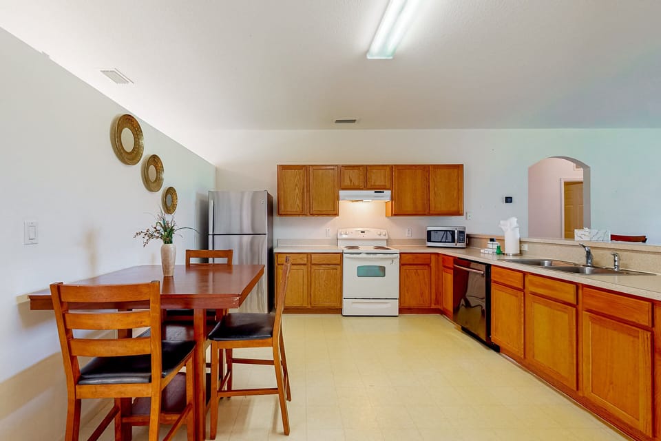 The kitchen is featured in the large open floor plan with fridge, oven, stove, microwave, dishwasher, and breakfast table.