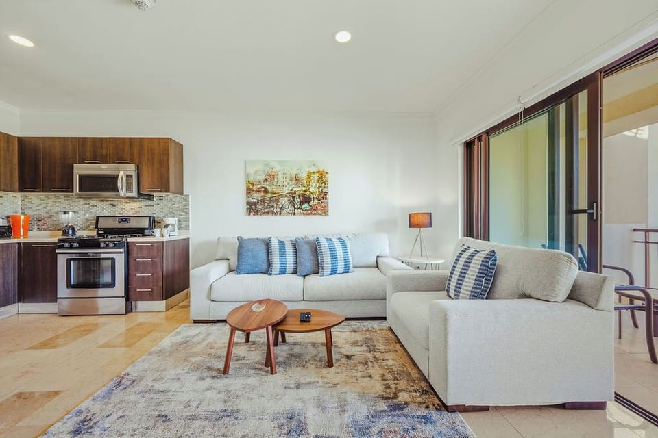 Spacious open-concept living area with cozy seating, a full kitchen, and direct access to the balcony for indoor-outdoor relaxation.