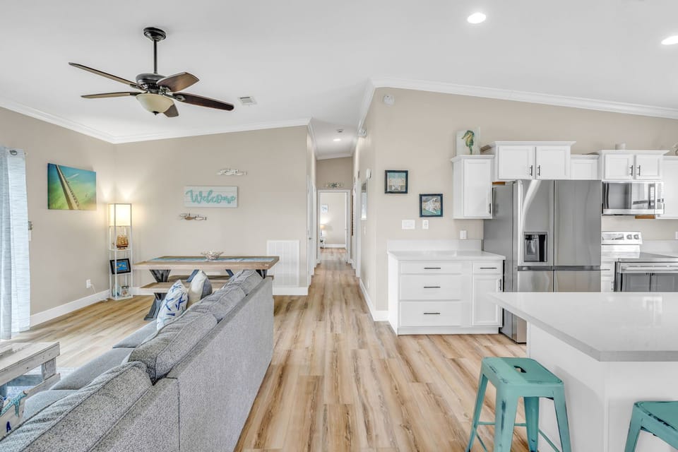Spacious open-concept layout combining living and dining areas, featuring tropical décor and unobstructed canal views in Marathon, FL.