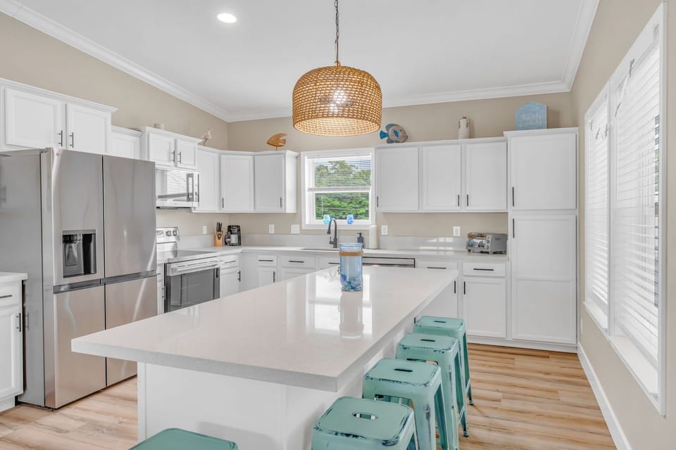 Modern cabinetry, stone countertops, and island seating inside a premier Florida Keys canal-front rental.