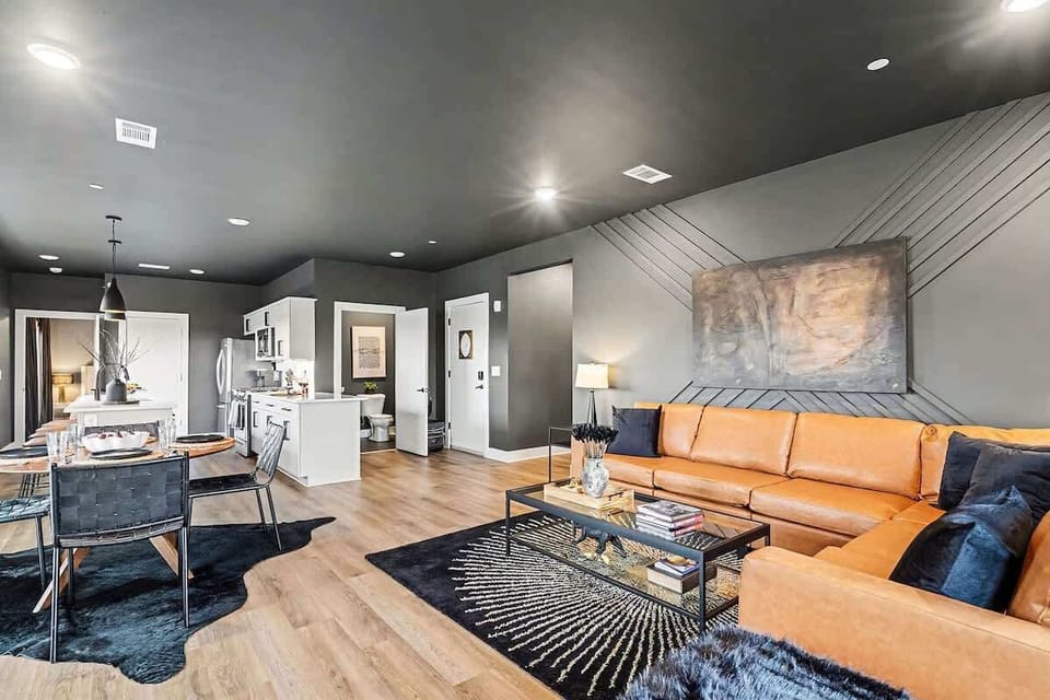 Bright and open concept living area with plush furnishings and a modern design that flows effortlessly into the dining area and open kitchen.