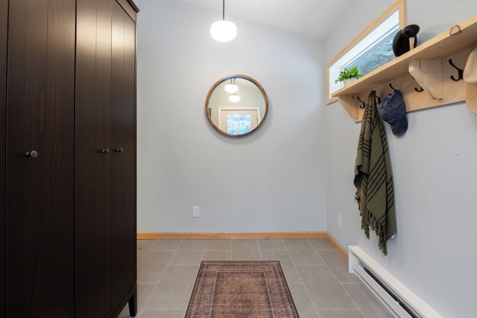 Thoughtfully designed entryway with built-in storage, coat hooks, and a welcoming mudroom setup for easy arrivals and departures.