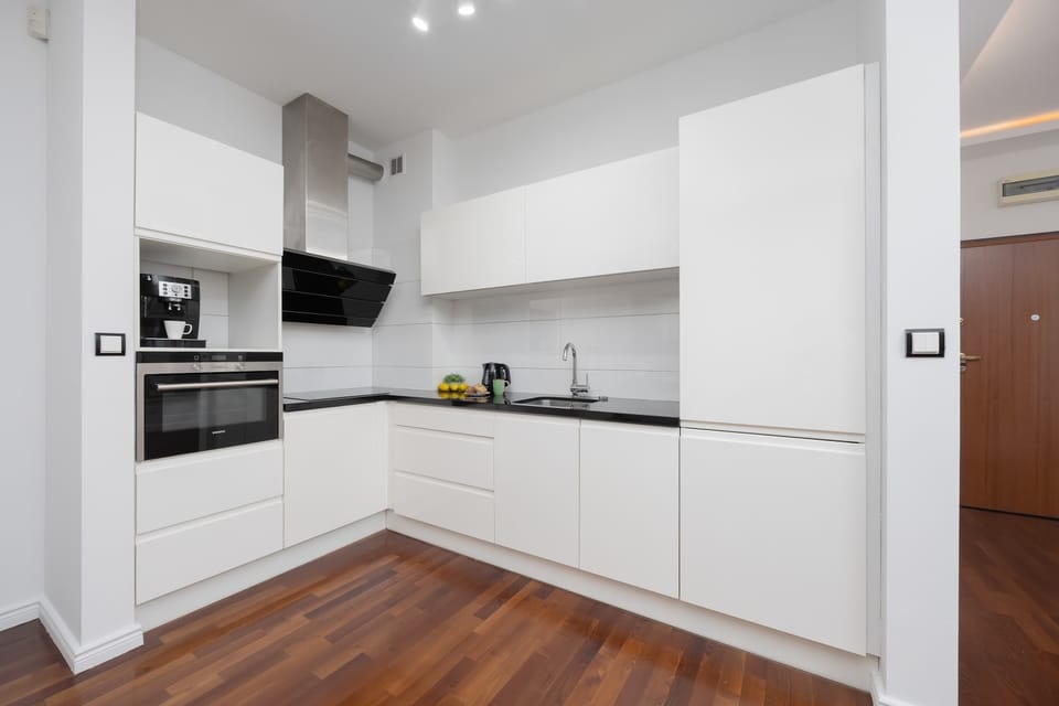 Modern kitchen with sleek white cabinetry and built-in appliances.